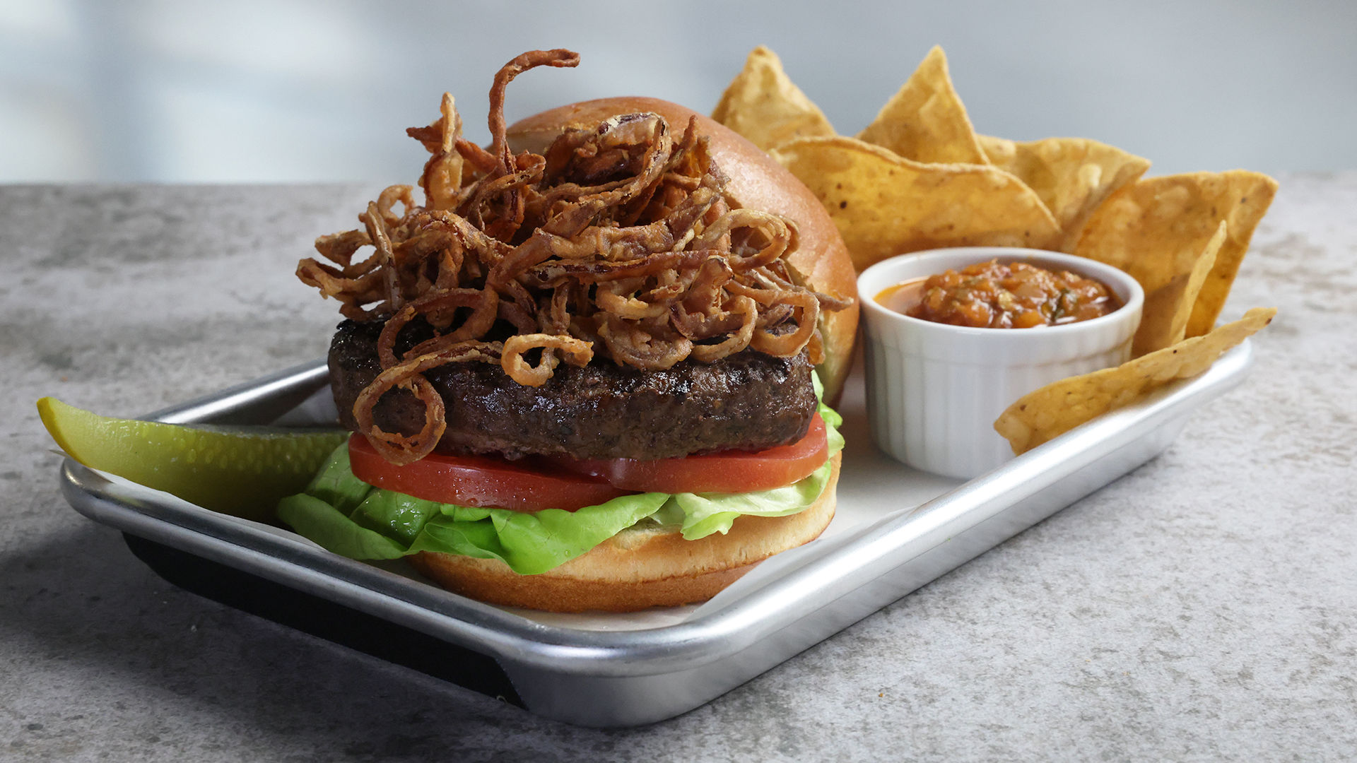 The Classic burger with shoyu fried onions, chips and salsa