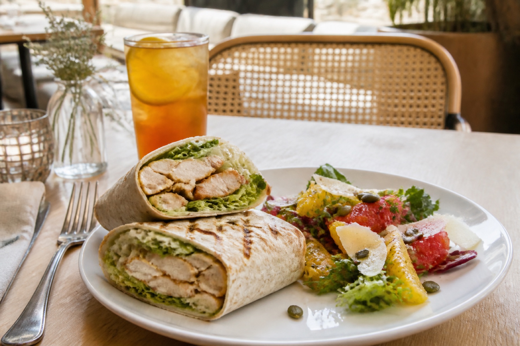 A chicken Caesar wrap and citrus salad with iced tea